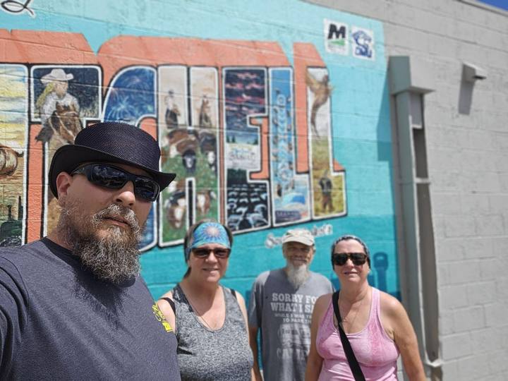 Riders in front of a colorful mural in Mitchell, South Dakota