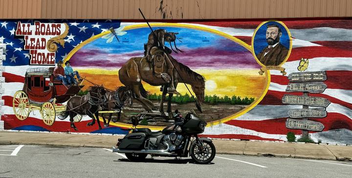 A motorcycle parked in front of a painted mural in Aurora, Missouri