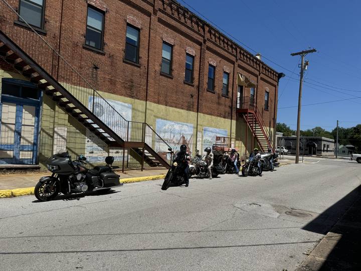 Two motorcycles parked beside an old brick building