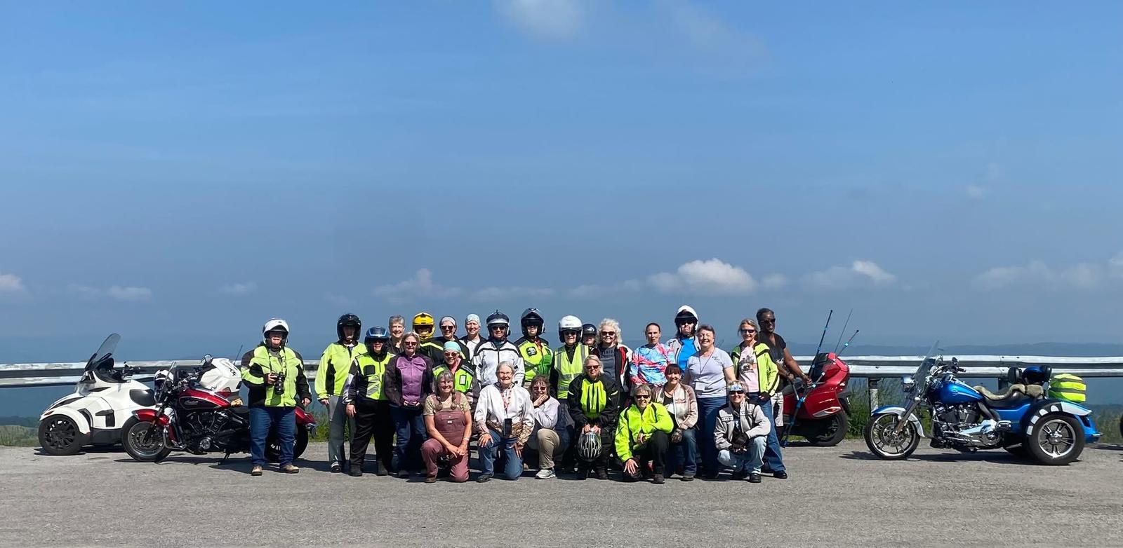 A large group of Lady Cruisers and friends with their motorcycles at a scenic overlook, 2025