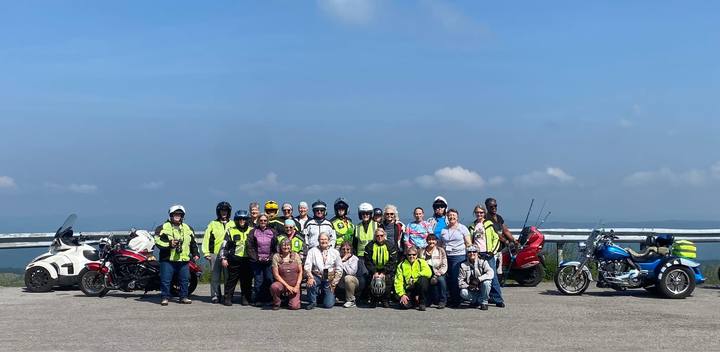 A large group of riders with their motorcycles at a scenic overlook