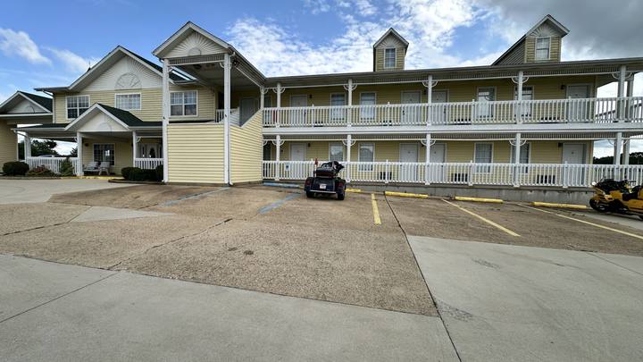 A two-story inn with one motorcycle parked in front